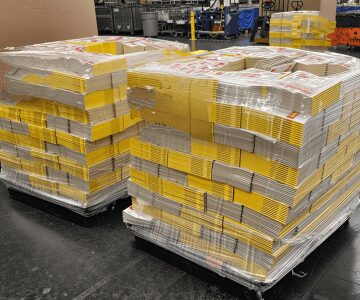 Stacks of yellow books on pallets.