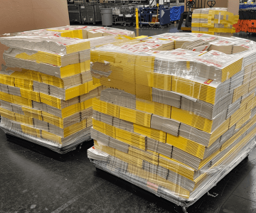 Stacks of yellow books on pallets.