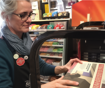 Woman scanning a book at checkout.